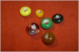einzelne Glasperlen in gelb, organge, grün, schwarz, braun