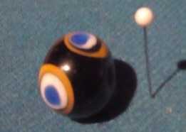 schwarze Perle mit Schichtauge gelb-schwarz-weiß-blau