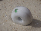 weiße Perle mit einem einzigen grünen transluzendem Punkt