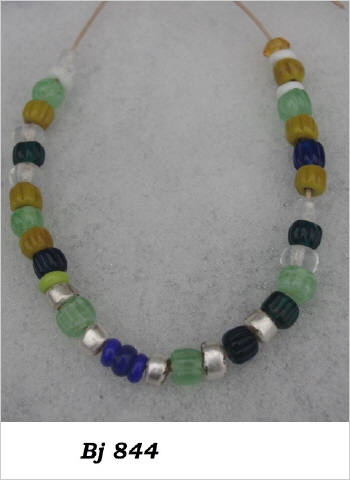 eine Kette aus etwa 30 Perlen in grün, blau, gelb sowie mit Silberfolie überzogen